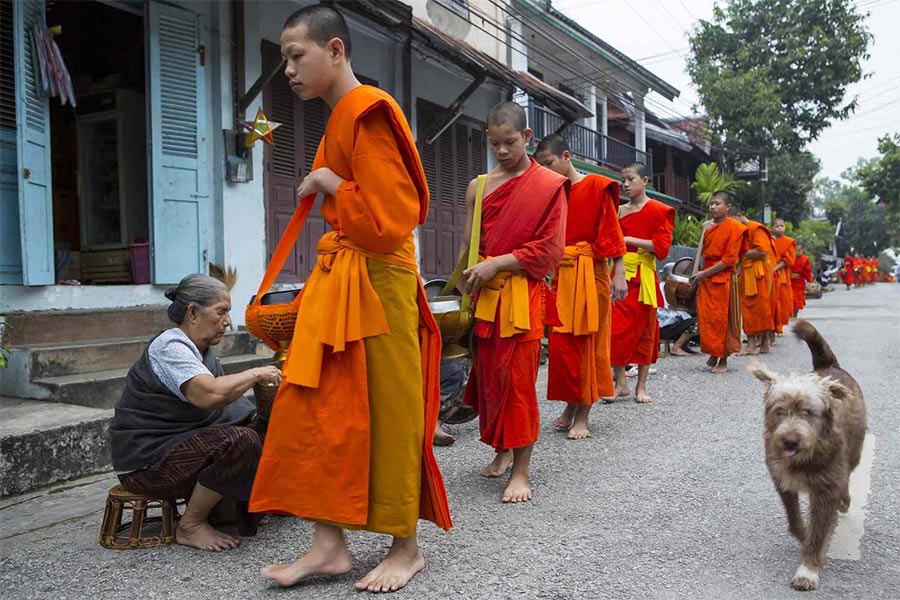 Monks take turns collecting rice offerings from locals