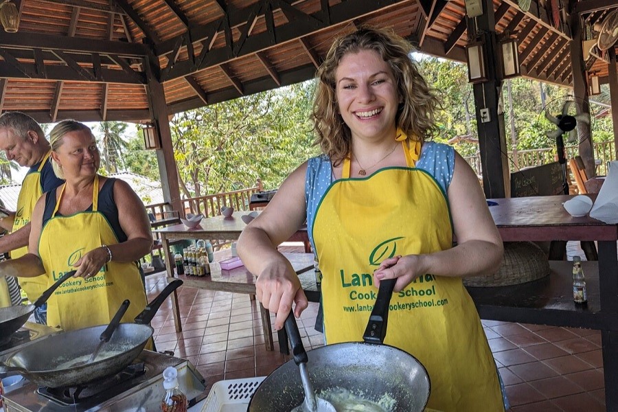 Attending a local cooking class to learn about Thai cuisine and have fun with friends