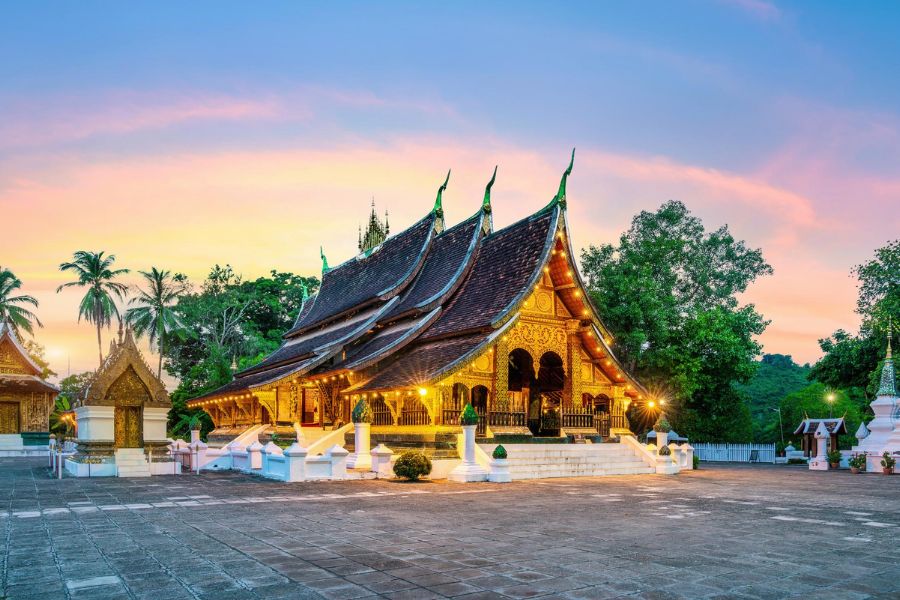 Wat Xieng Thong temple glows warmly at twilight before the night's festivities