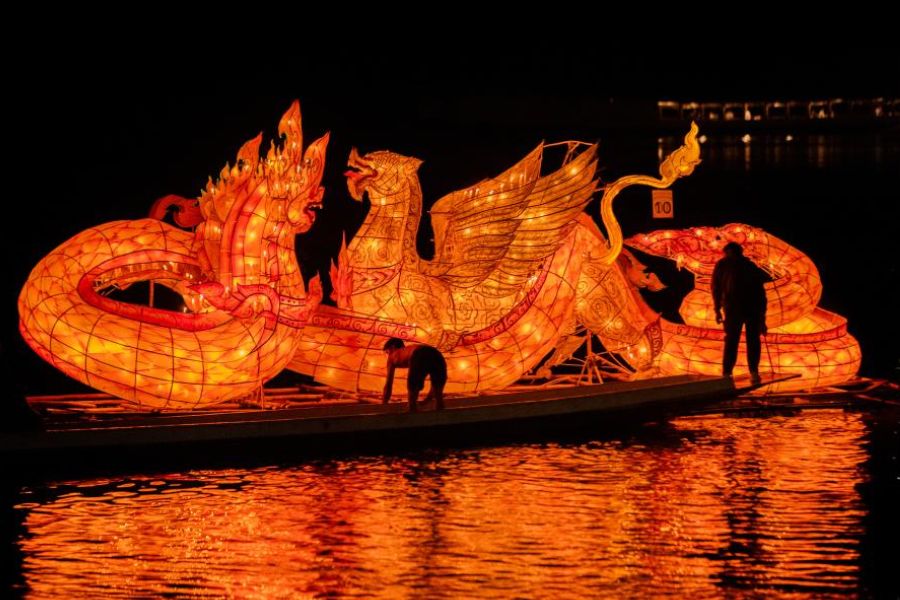 A vibrant Naga-shaped fire boat parades through the streets of Luang Prabang