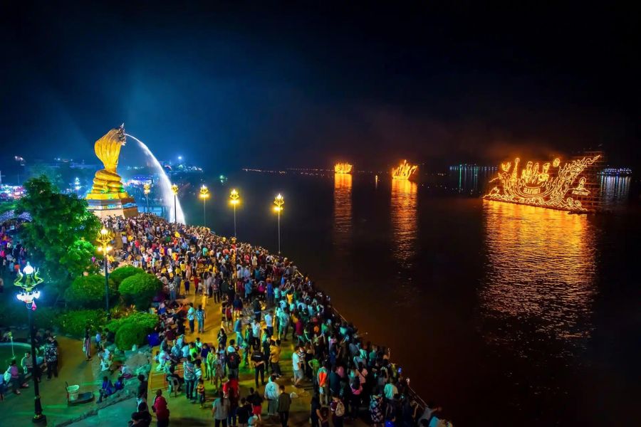 The Mekong River lights up with glowing fire boats and floating offerings at night
