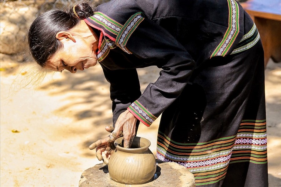 M’nong artisans form clay on a large piece of wood