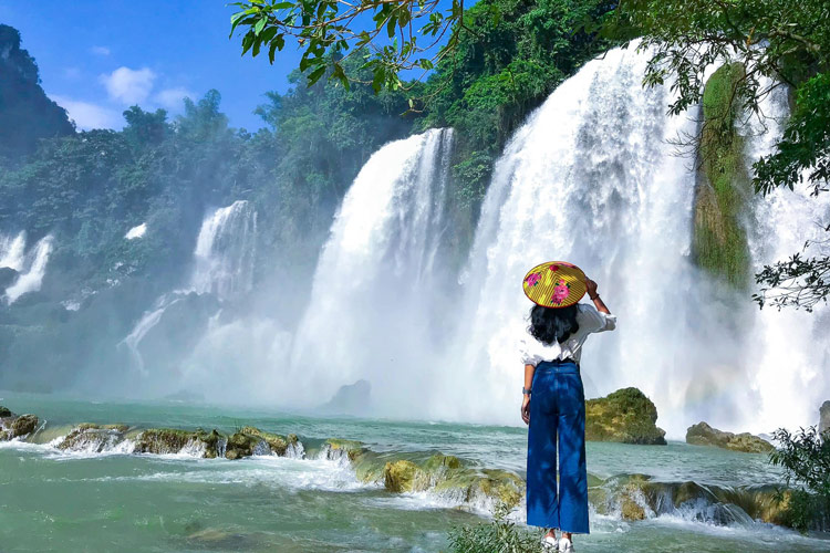 Tourists take photos with the waterfall