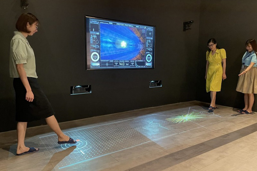 Visitors try a motion-activated floor display at the Matter & Particles Lab