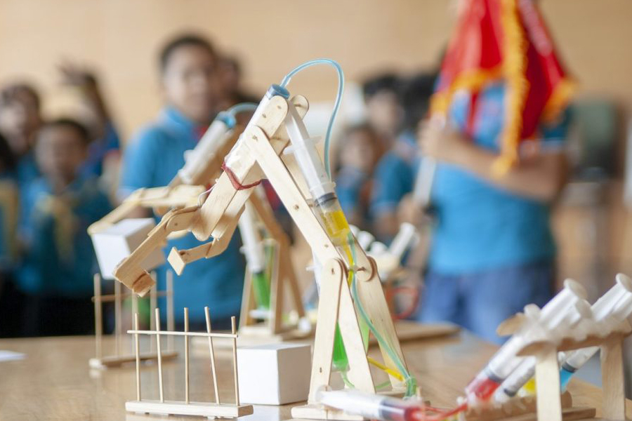Students build hydraulic robotic arms during a hands-on STEM workshop.