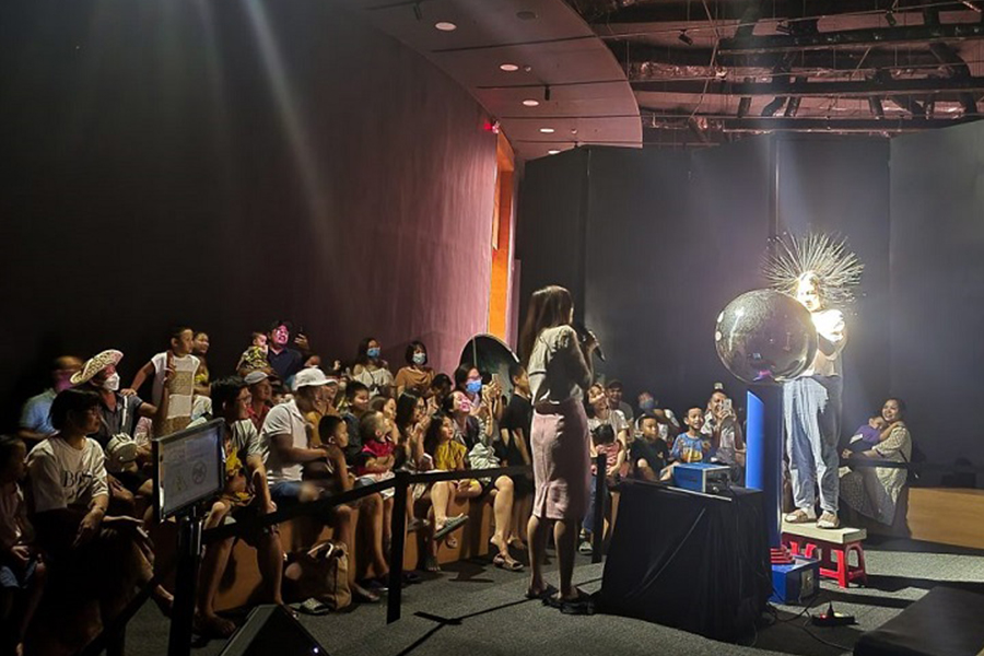 A child enjoys the static electricity effect with the Van de Graaff generator in “Why Is That?” Room
