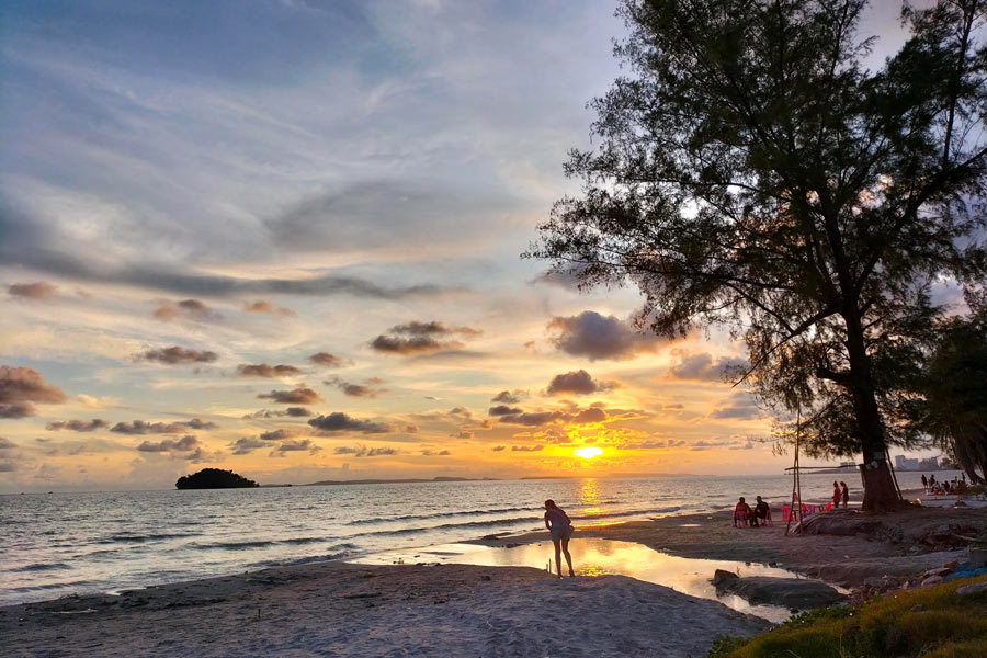 Many visitors gather on the beach in the late afternoon to witness the sun setting over the Gulf of Thailand, creating a beautiful and tranquil spectacle