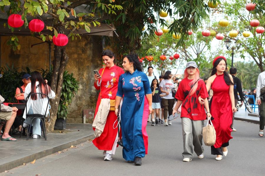 A foreign visitor wanders through Hoi An's ancient town in ao dai during the TET holiday