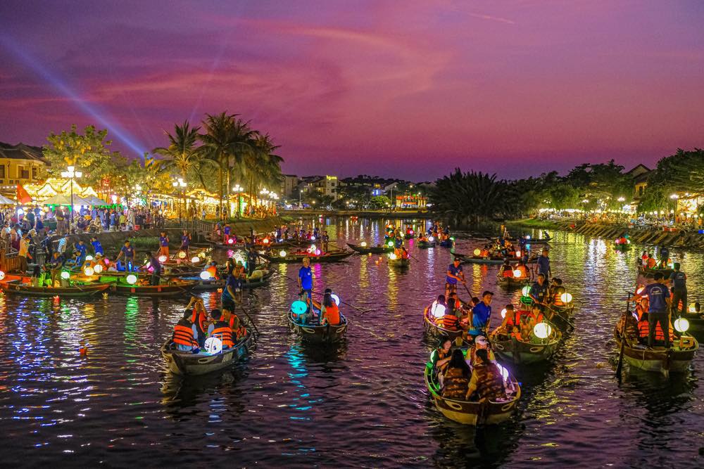 Tourists take boat rides to release lanterns on the Hoai River