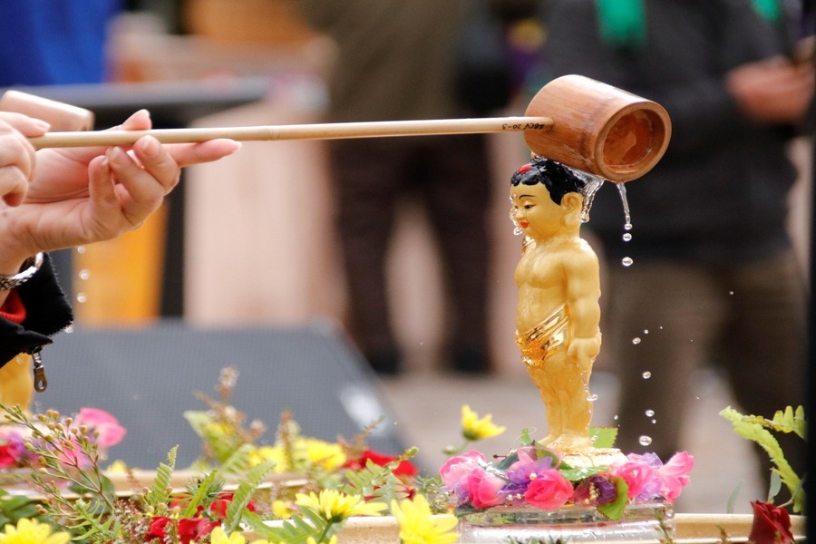 Monks showering Buddha statue