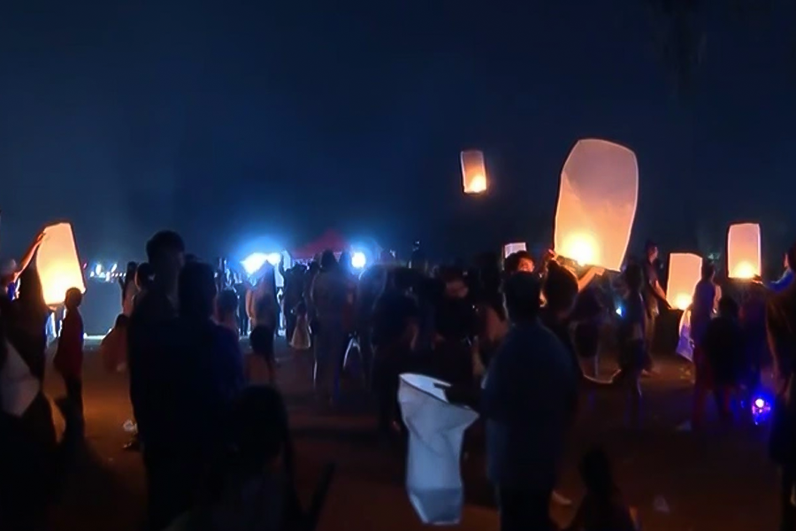 People releasing lanterns symbolizing hope and good luck during Boun Wat Phou 