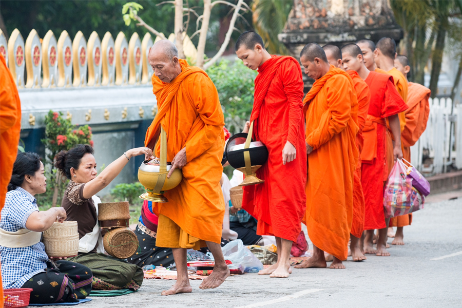 Monks receiving food from the locals during Tak Bat