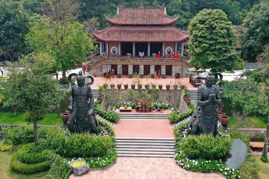 The scene outside the temple, with two guardian deities standing sentinel on either side