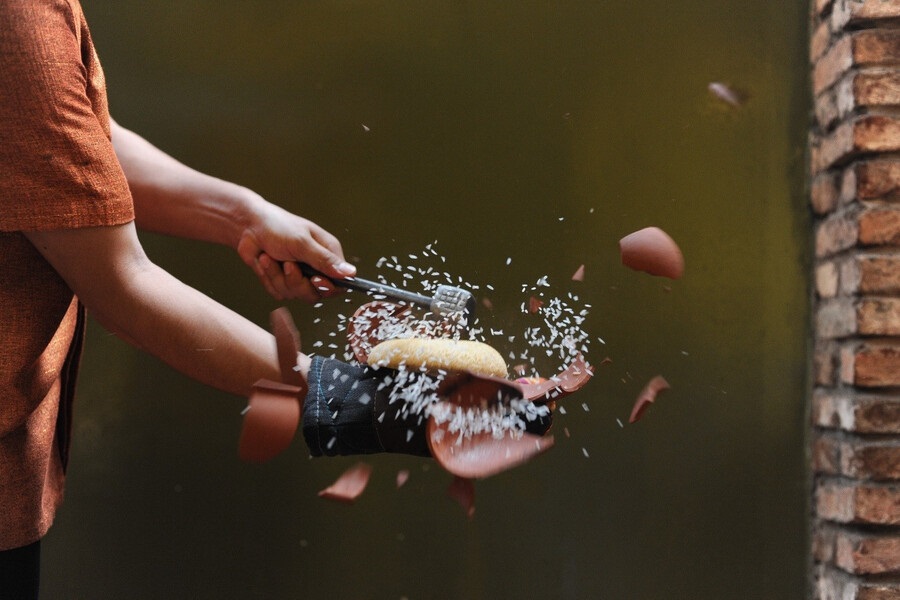 A waiter will smash the clay pot and toss rice for another to catch on a plate. Photo: Com Nieu Sai Gon