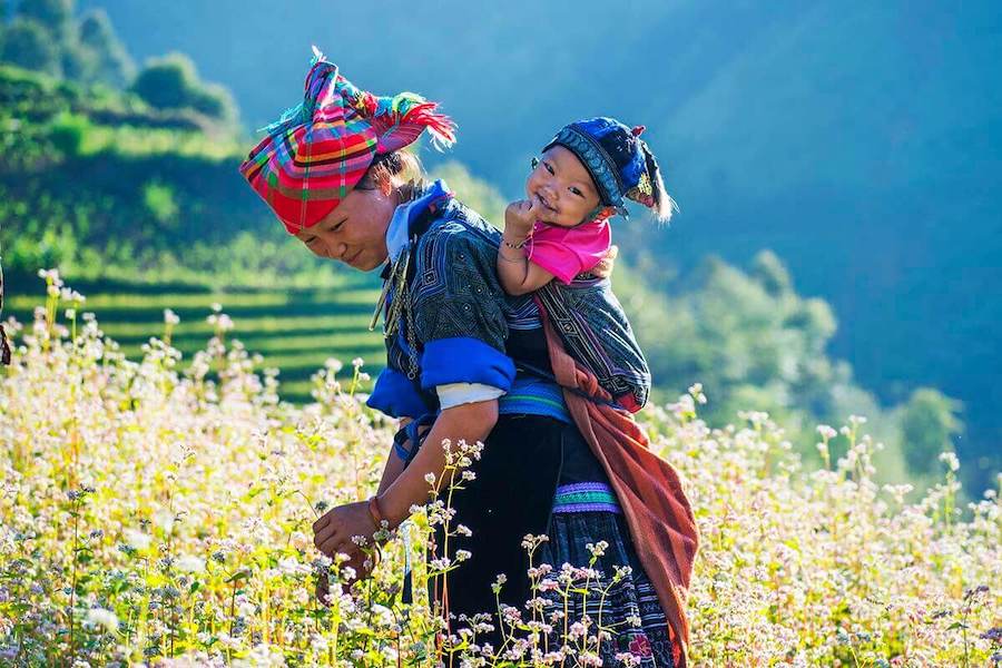 Black H'mong women usually carry child pick-a-pack astride on back to go work on fields - Photo: Goldenholidaytravel