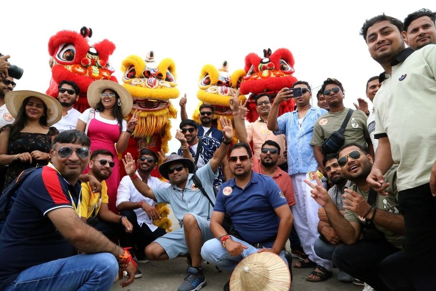 Indian tourists are taking photos with the lion dance team. Photo: Vietnamnet