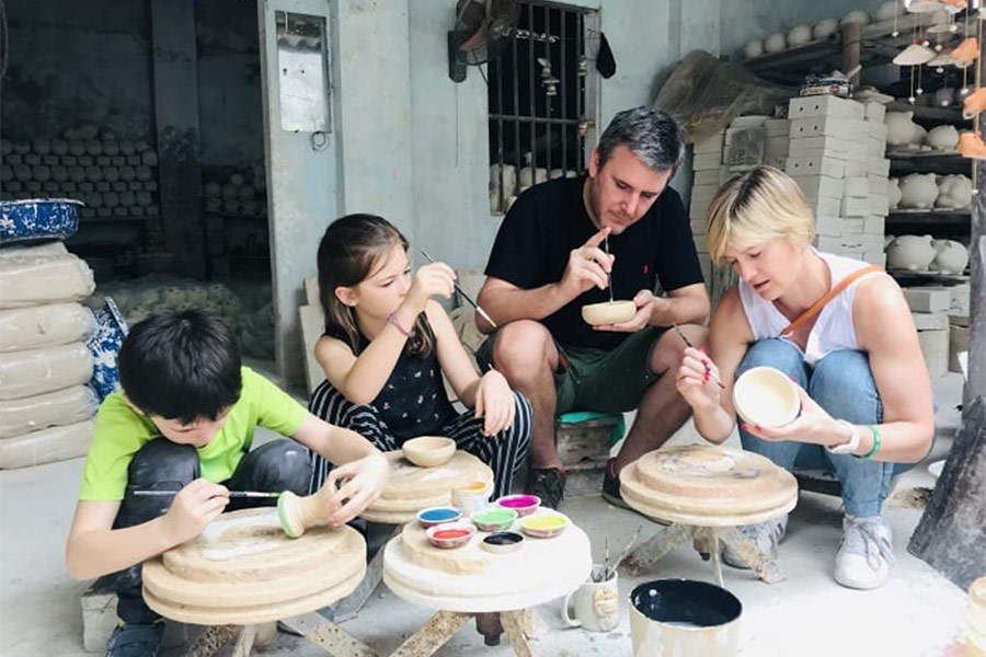 A family is making ceramic vase in Bat Trang village