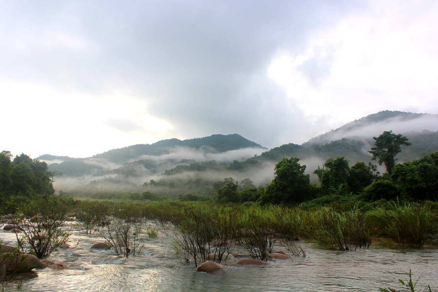 White clouds dance playfully over the overlapping mountain ranges