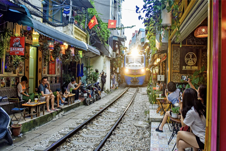 People sit in the railway cafes along the street to watch the train passing by (Source: Internet)