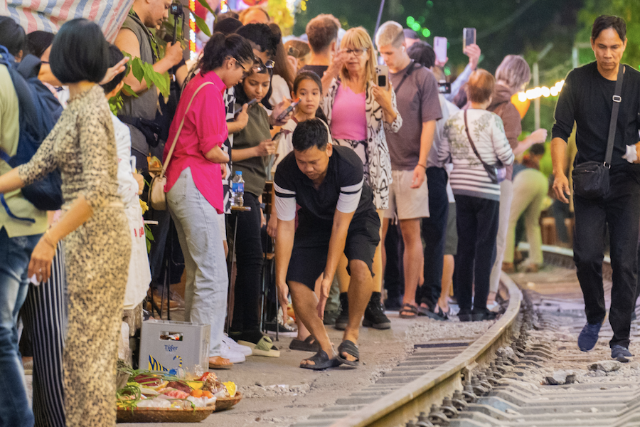 The cafe’s owner reminds the visitors to keep a safe distance from the railway when the train is about to come (Source: VnExpress)