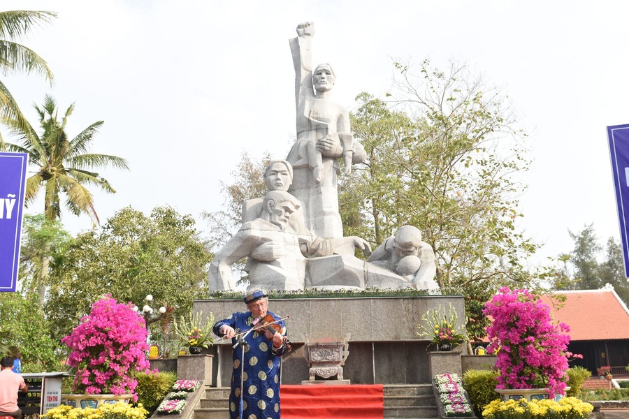 An American war veteran plays the violin in front of the memorial. Photo: Quang Ngai Tourism