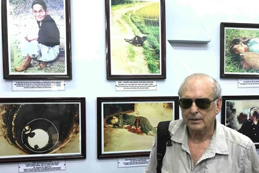 Mr. Haeberle stands beside the photographs he took during the massacre. Photo: NVCC