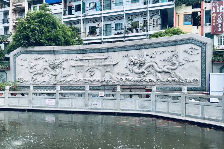 The fish pond and the relief sculpture depicting the carp turning into a dragon outside the assembly hall. Photo: Tripgoquest