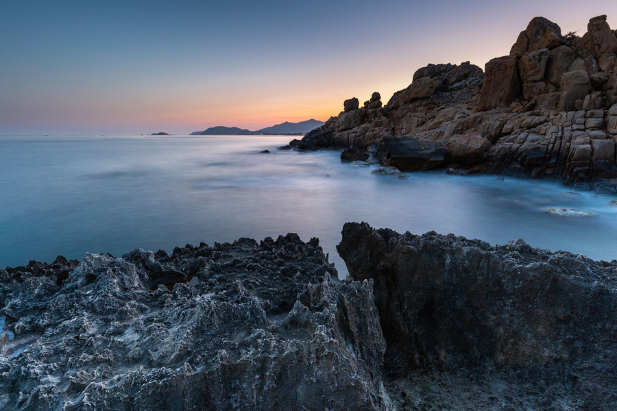 Towering coral rock formations stand proudly along the shoreline. Photo: Pham Tuan Anh