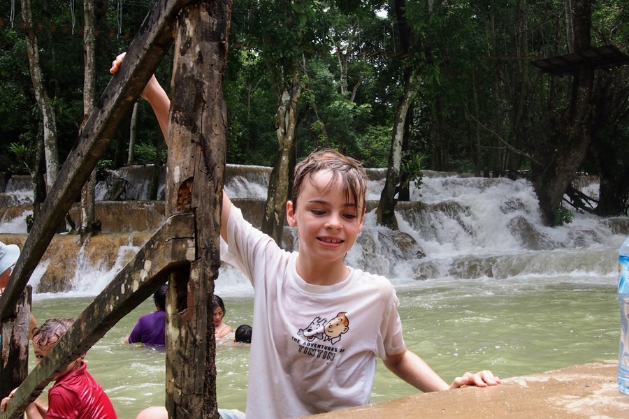 Kids enjoying a swim at Kuang Si Waterfalls