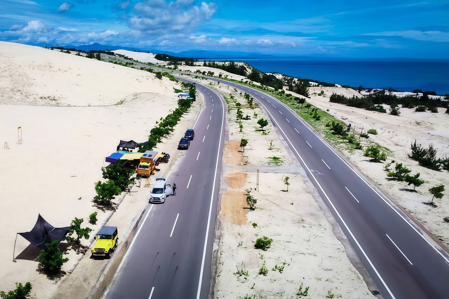 The road to Bau Trang has the blue sea on one side and white sand on the other
