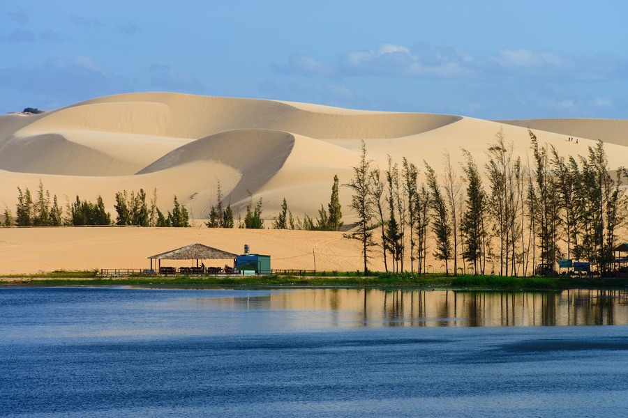 The contrast between the deep blue of the lake and the white of the sand dunes makes this place feel almost unreal