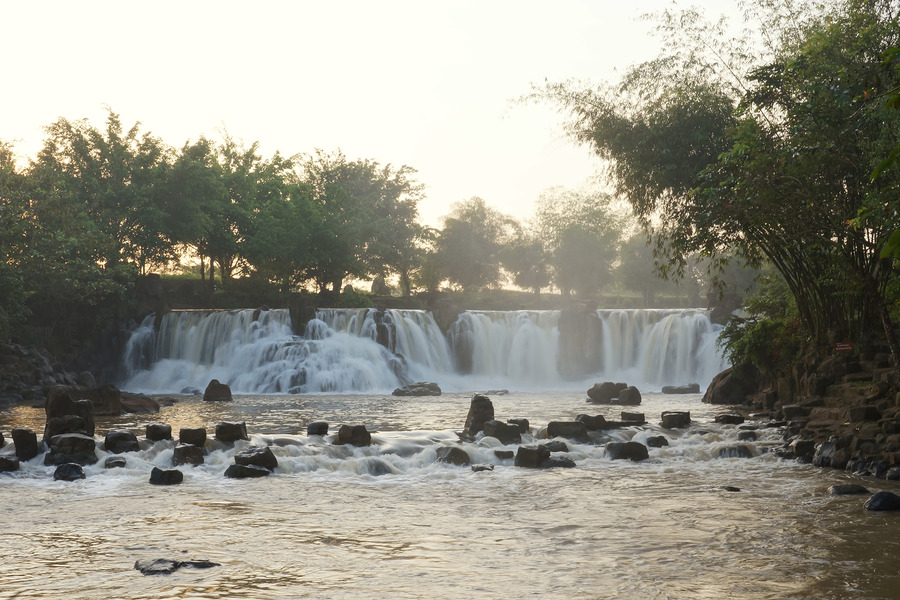 The waterfall is not very tall, so the flow of water cascades down quite gently