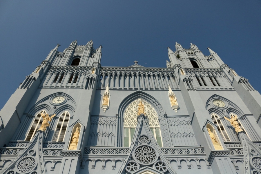 The two bell towers are intricately designed, accompanied by statues