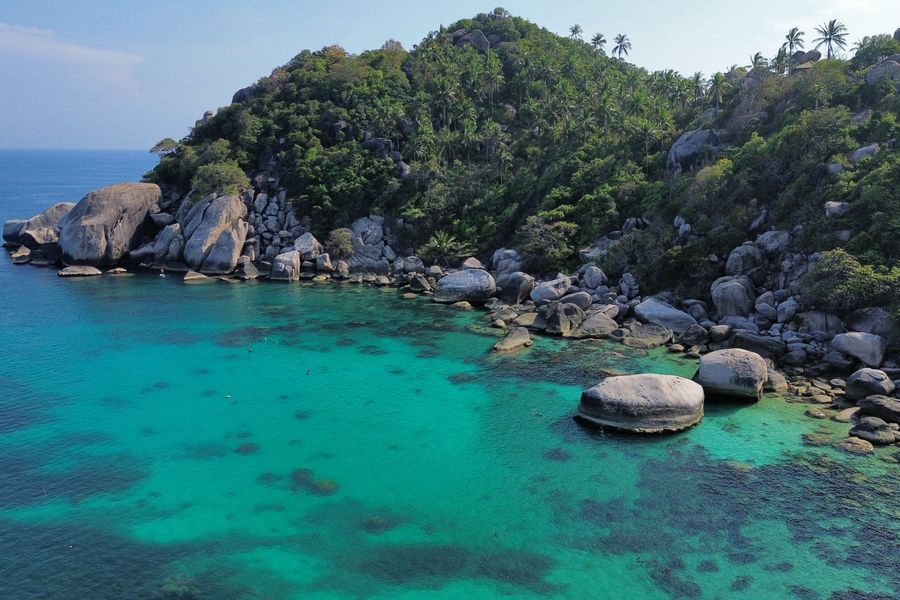 Discover the breathtaking beauty of the turquoise waters and rocky coastline of Shark Bay on Koh Tao, Thailand.