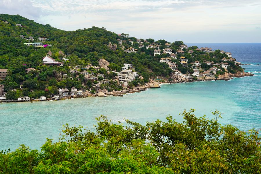 Stunning aerial view of Shark Bay on Koh Tao, featuring turquoise waters and lush green vegetation.