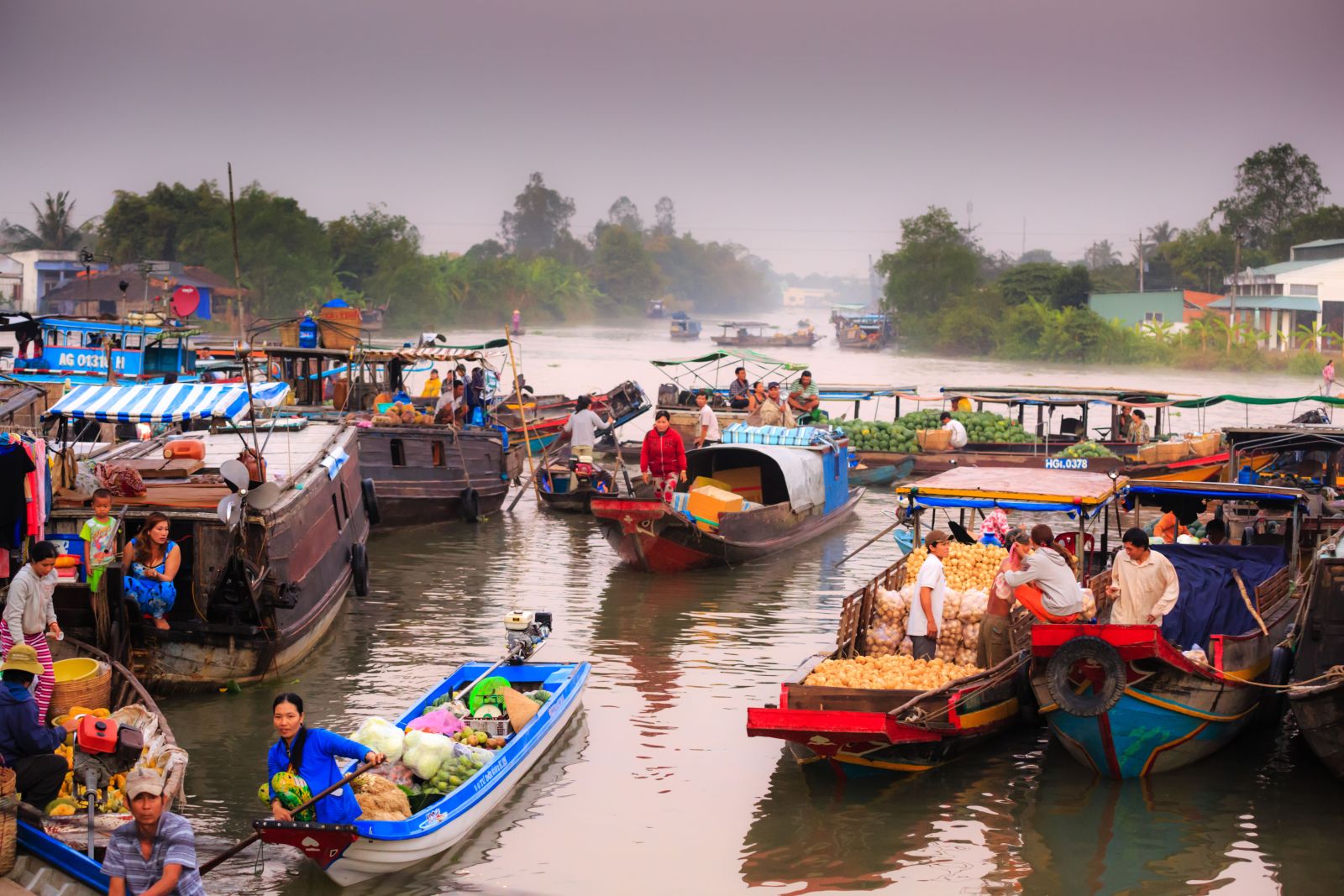 A bustling floating market scene featuring locals trading fresh produce from traditional boats on a tranquil river.