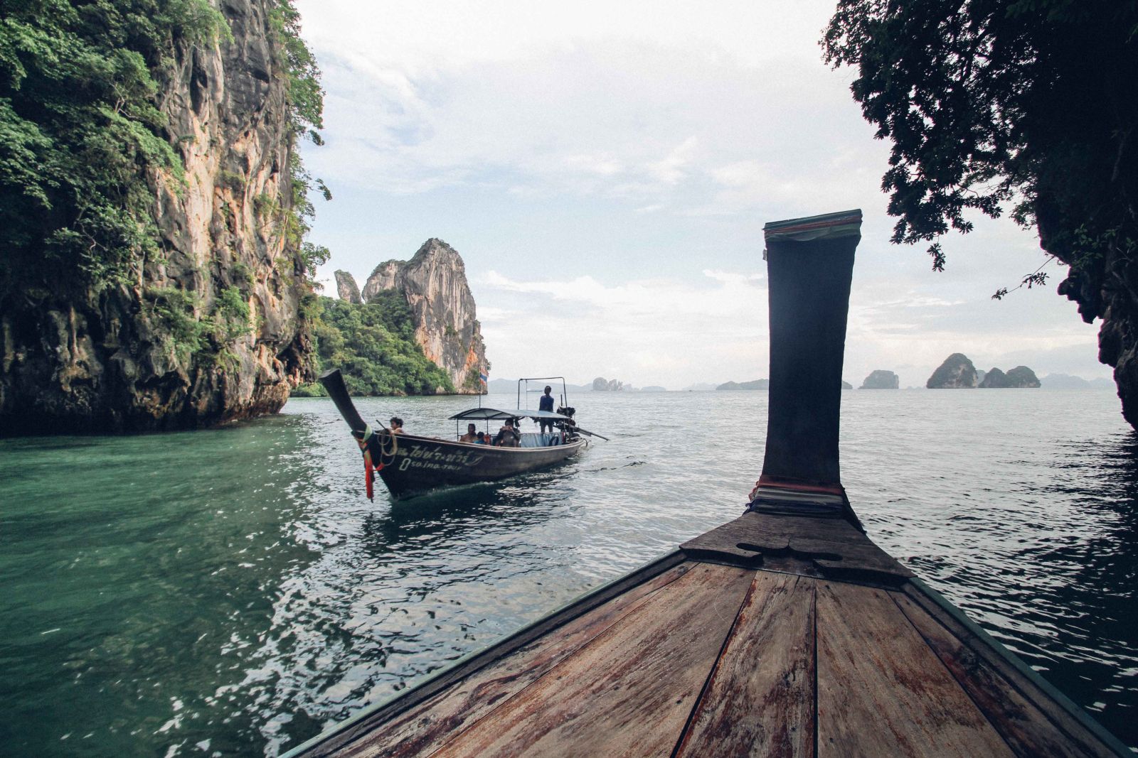 Explore Thailand's tranquil waters and towering cliffs in a traditional longtail boat.