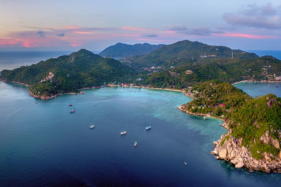 A stunning aerial view of Koh Tao, Thailand, at sunset, surrounded by turquoise waters.