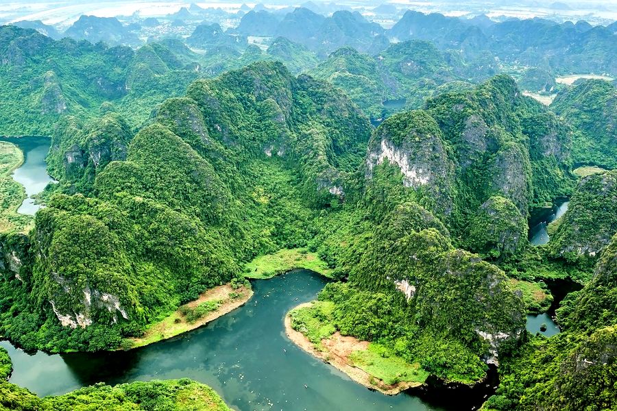 A stunning aerial view of the lush green highlands in Dak Ya, Gia Lai, Vietnam, featuring rivers and forests.