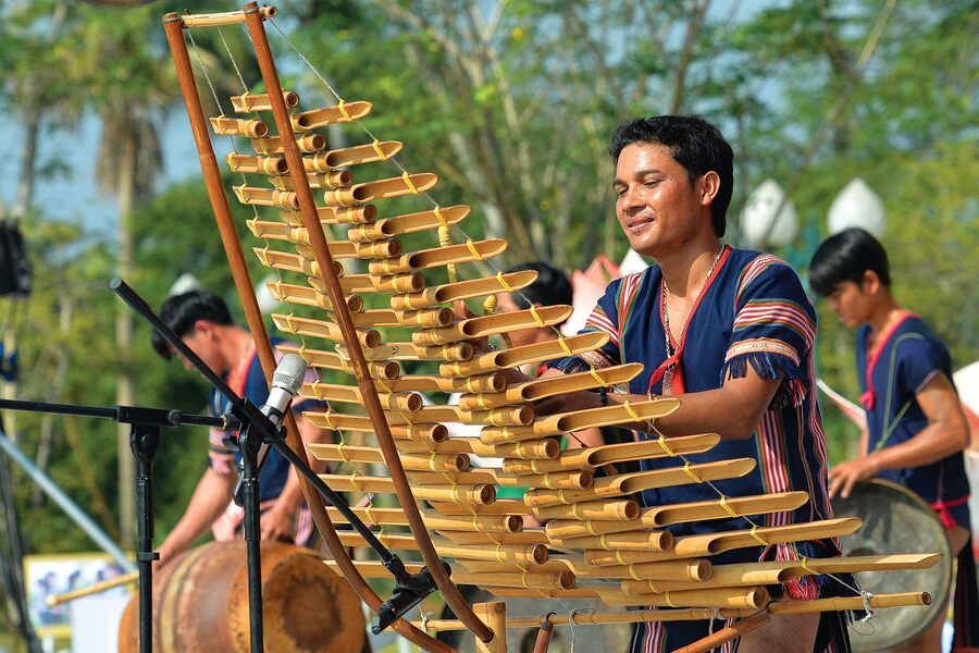 T'rung player strikes the bamboo tubes of the instrument to  create music. Photo: Thong tin Doi ngoai