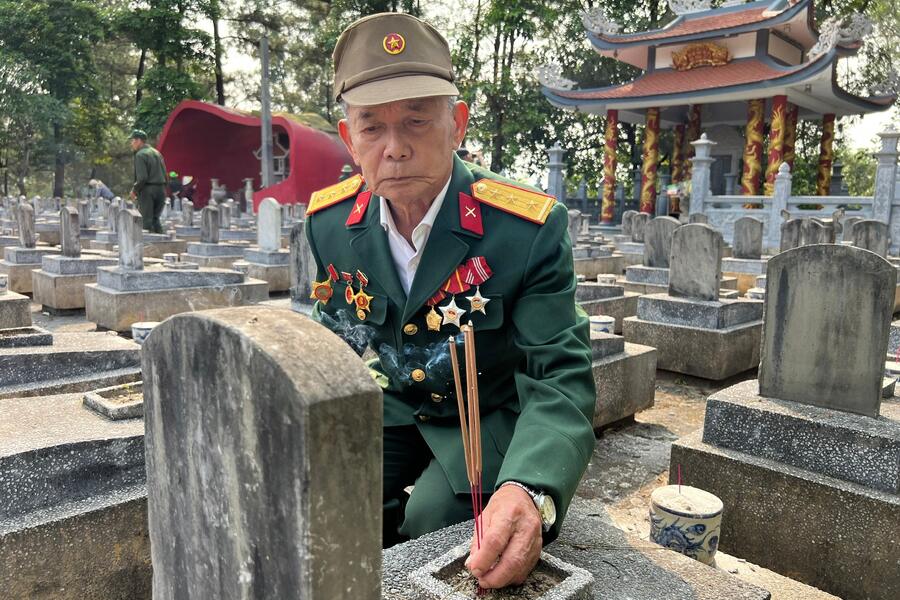 A veteran visits his old comrades. Photo: Binh Thuan Newspaper