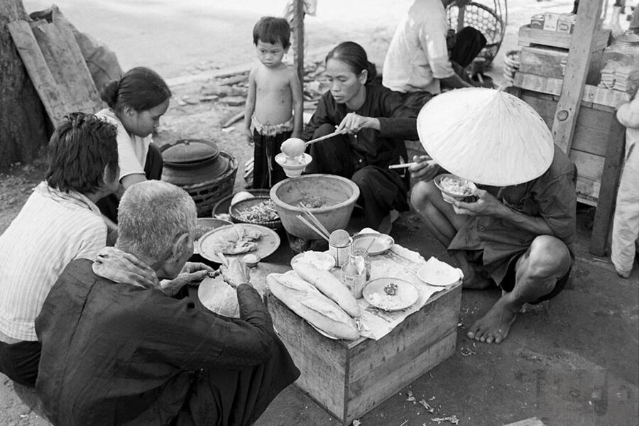 The mother or the eldest sister will sit next to the rice pot and serve rice for the whole family. Source: LIFE Magazine