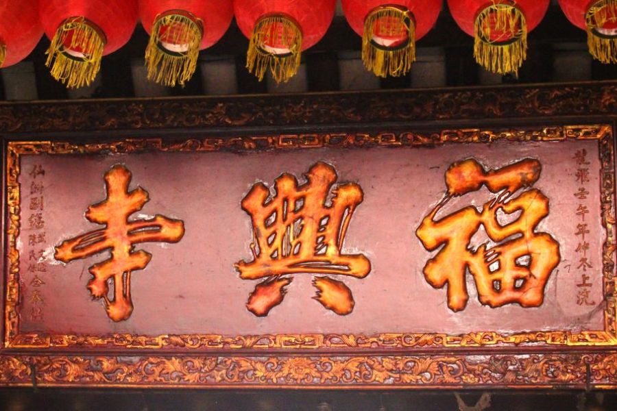 Hanging in front of the ancestral hall is an ornate horizontal panel engraved with intricate patterns.