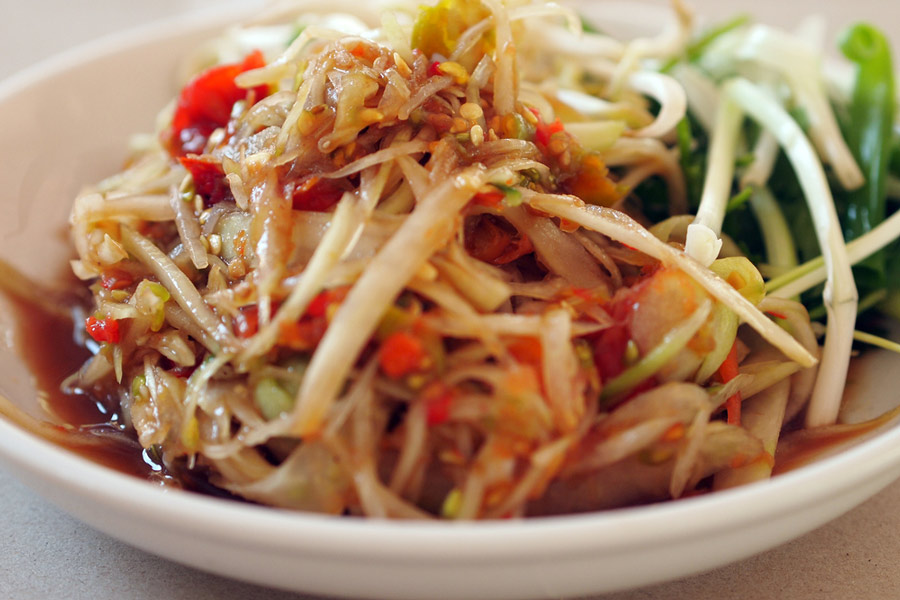 This vibrant salad, made from shredded green papaya, chili, lime, and fish sauce, offers a perfect blend of sweet, sour, and spicy flavors